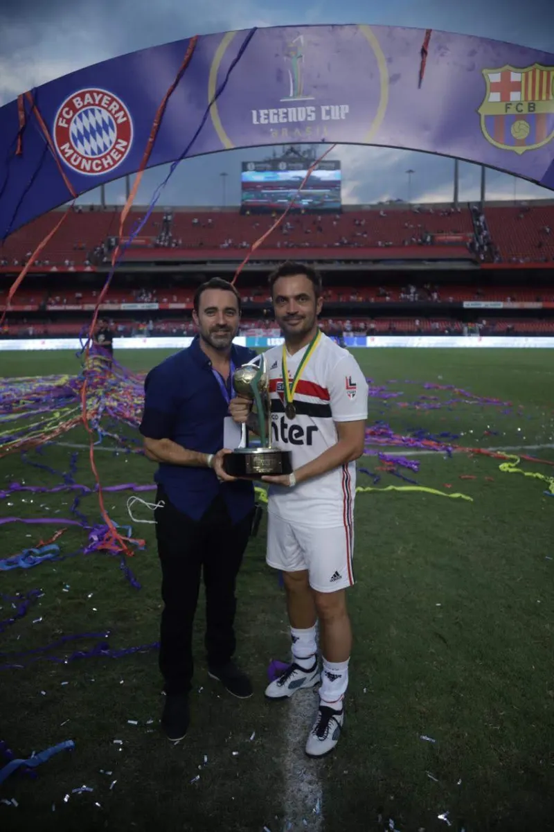 Duas pessoas com o troféu da Legends Cup Brazil no Morumbi